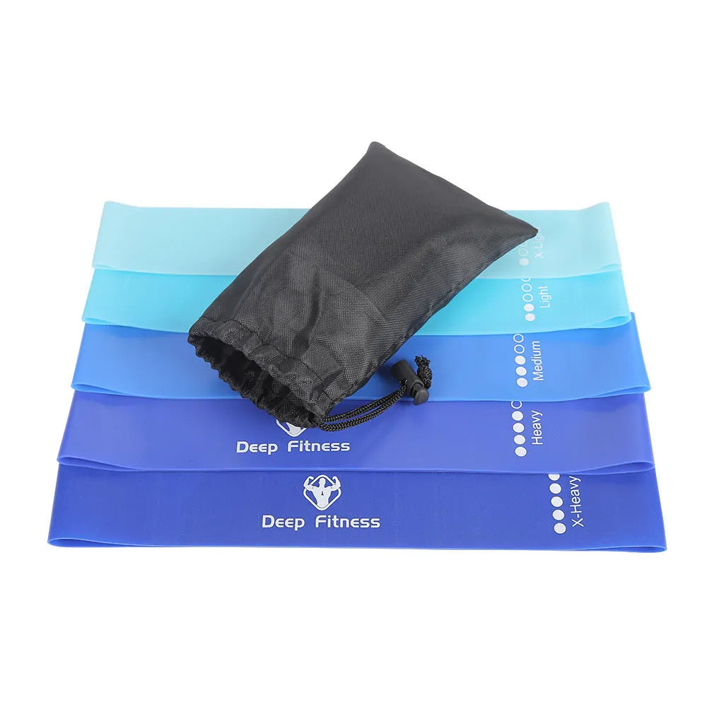 Yoga hip resistance band set in six colours from 0.4mm green to 1.2mm black laid flat on a surface