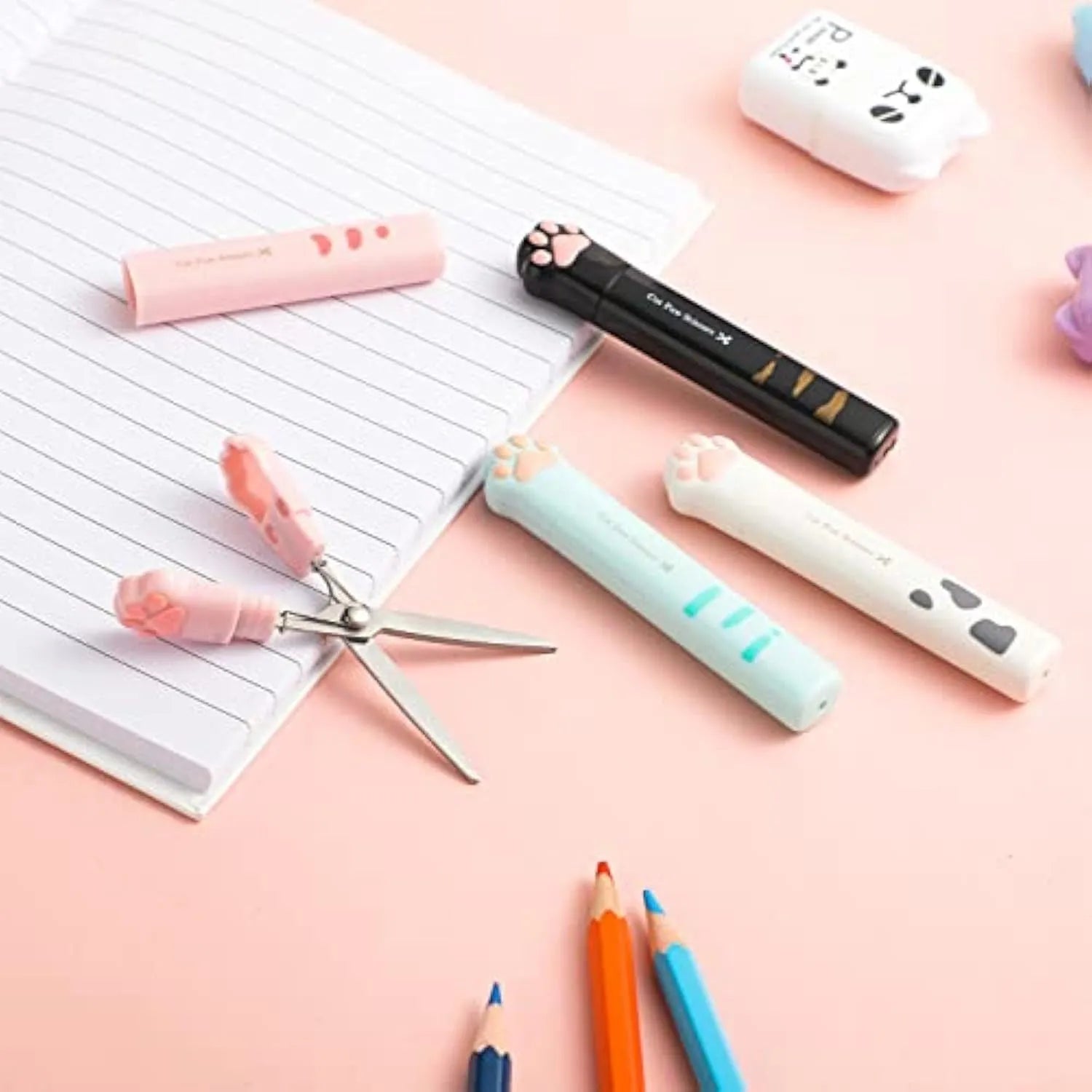 Cat paw design mini folding safety scissors in four colours: black, blue, pink, and white.