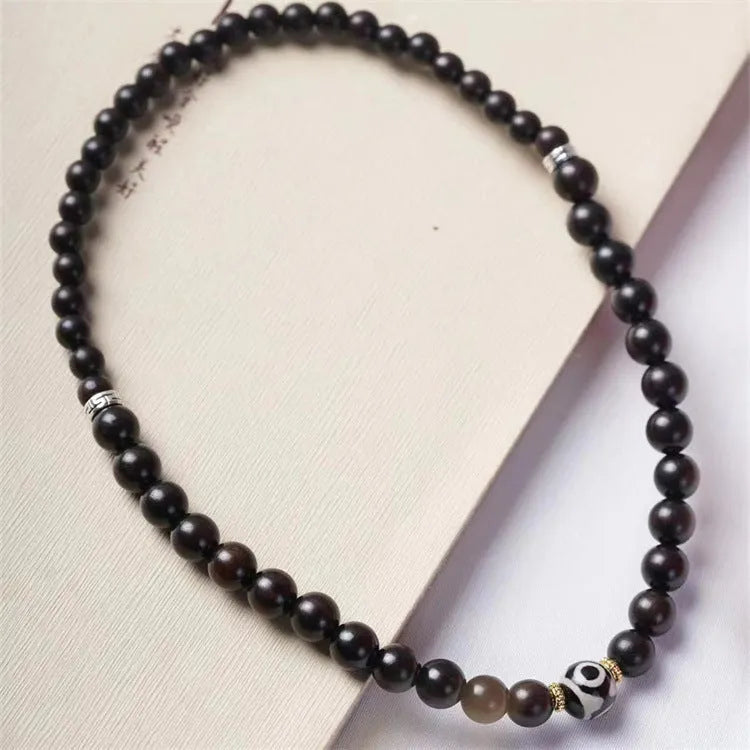 Dark ebony wood bracelet with 8mm Tibet-style beads and circle elements on wrist