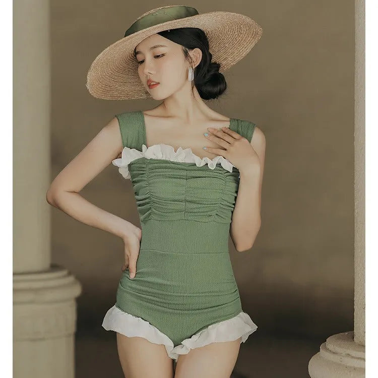 Black high-waisted one-piece swimsuit on a mannequin, showing quick-dry fabric and slimming cut.
