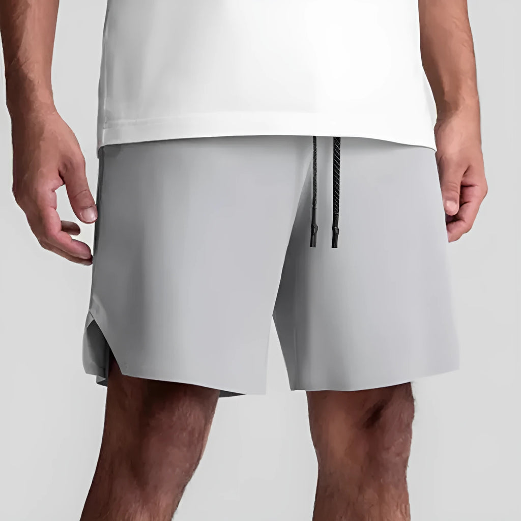Men's grey seamless sports shorts with a straight-leg, knee-length cut on a mannequin.