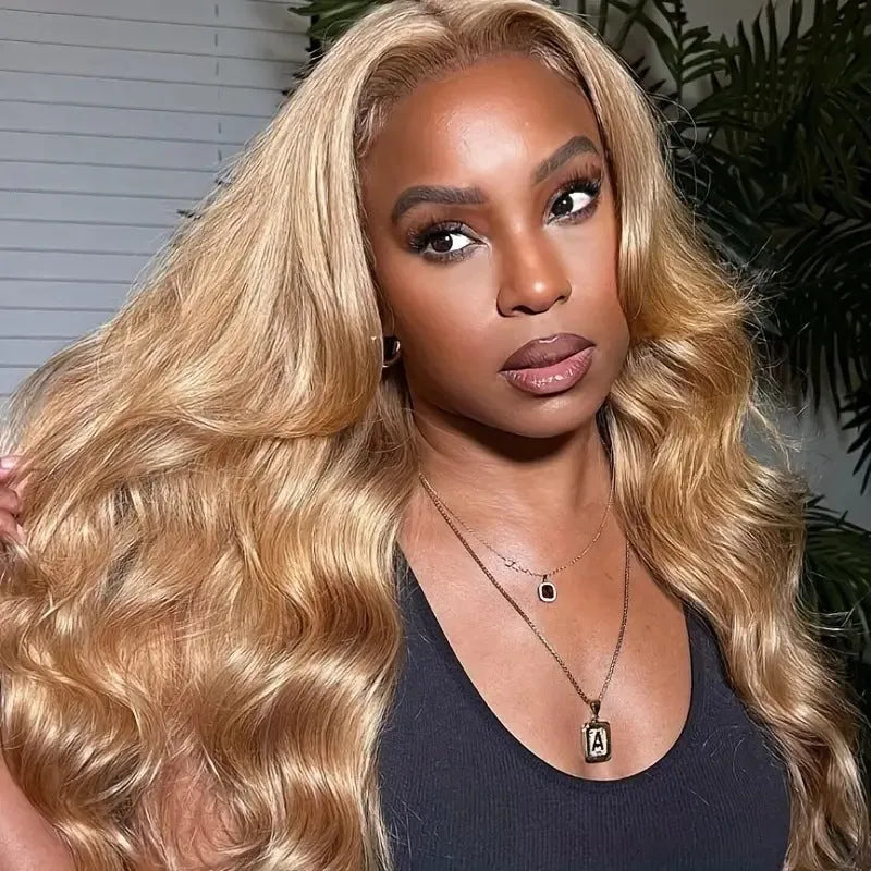 Light brown long curly synthetic wig with big waves and side bangs displayed on a stand.