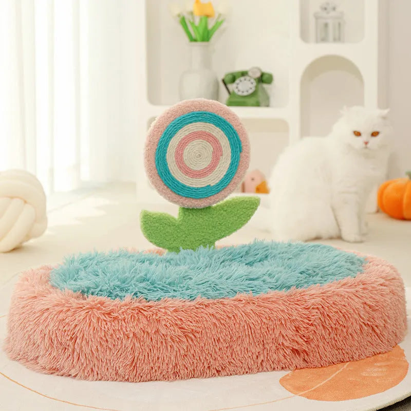 Pink elliptical plush cat bed with a removable, washable cover on a wooden floor.