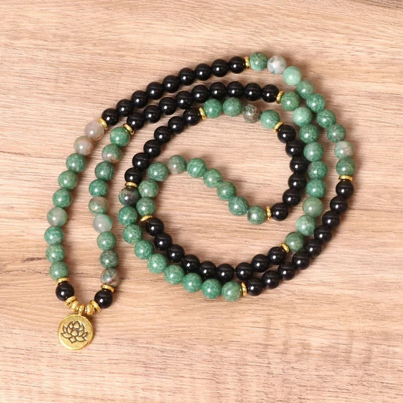 Green and black alloy bead elastic bracelet on a wrist.