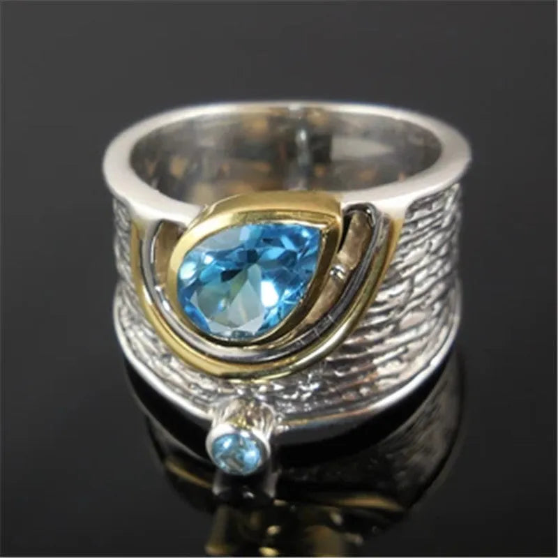 Blue drop-shaped women's alloy ring with inlaid zircon rhinestones on a finger.