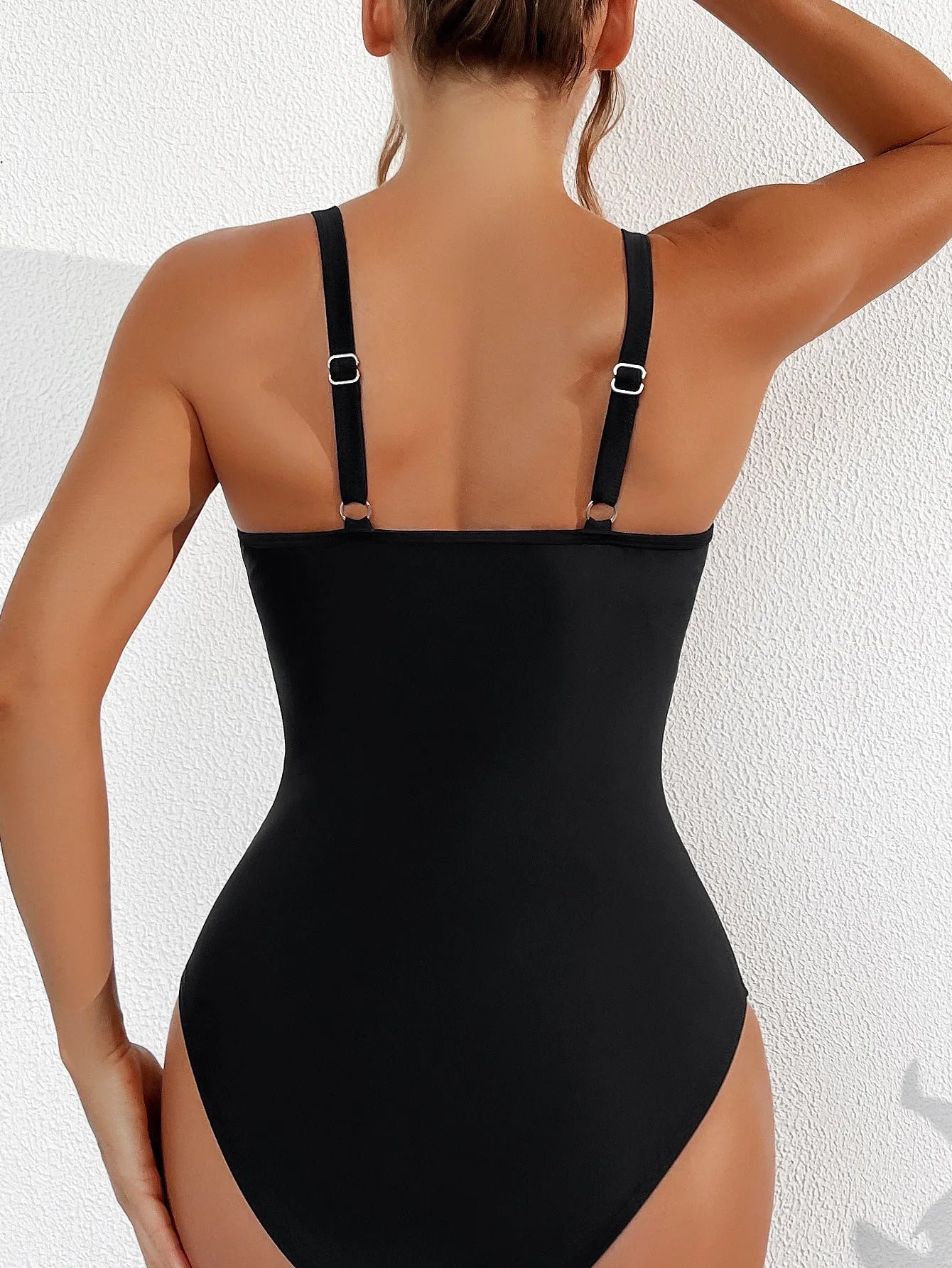 Black women's one-piece swimsuit with halter neck and briefs style.