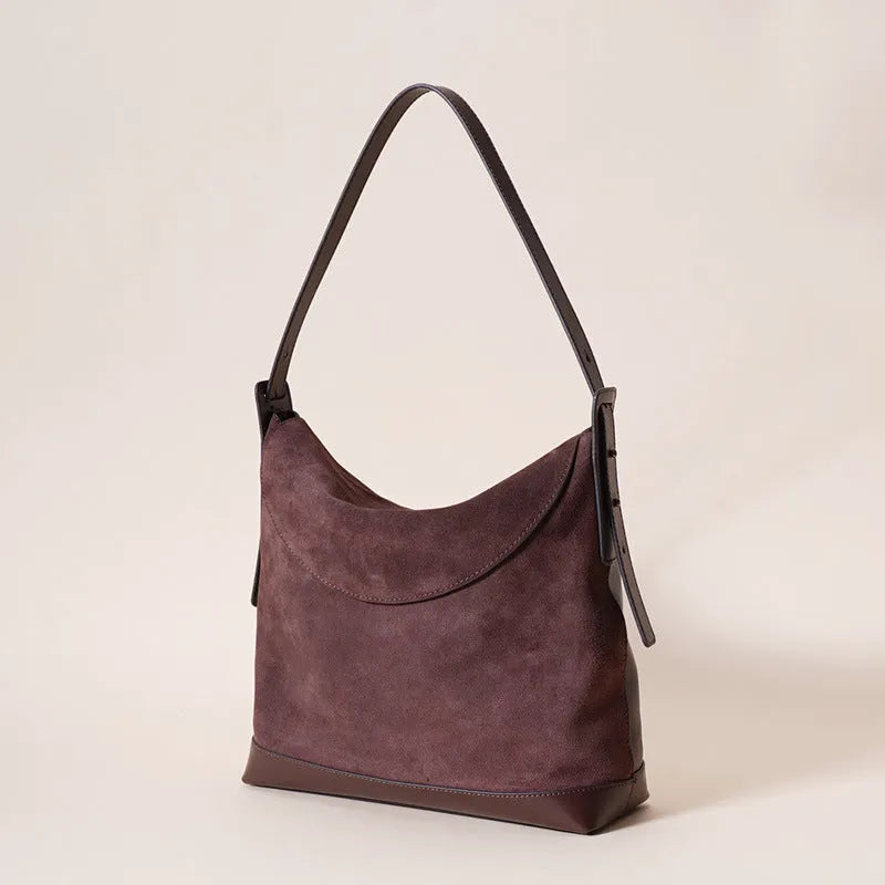 Light brown genuine leather women's retro shoulder bag with clamshell opening on a table.