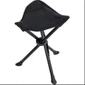 Green folding 3-leg camping stool on grass, lightweight tripod design for outdoor seating
