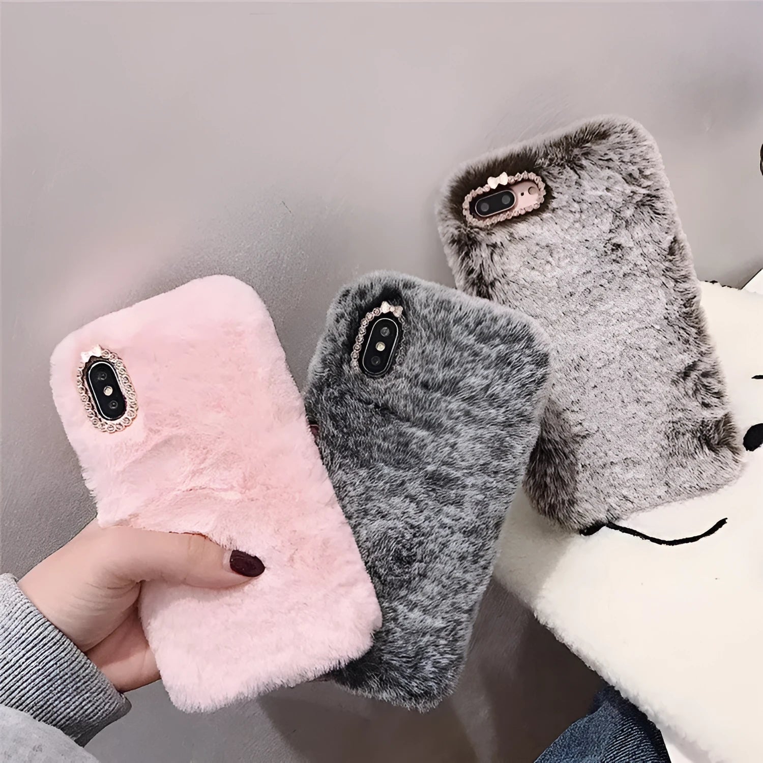 Silicone iPhone case with grey faux rabbit hair plush back and rhinestone decoration.