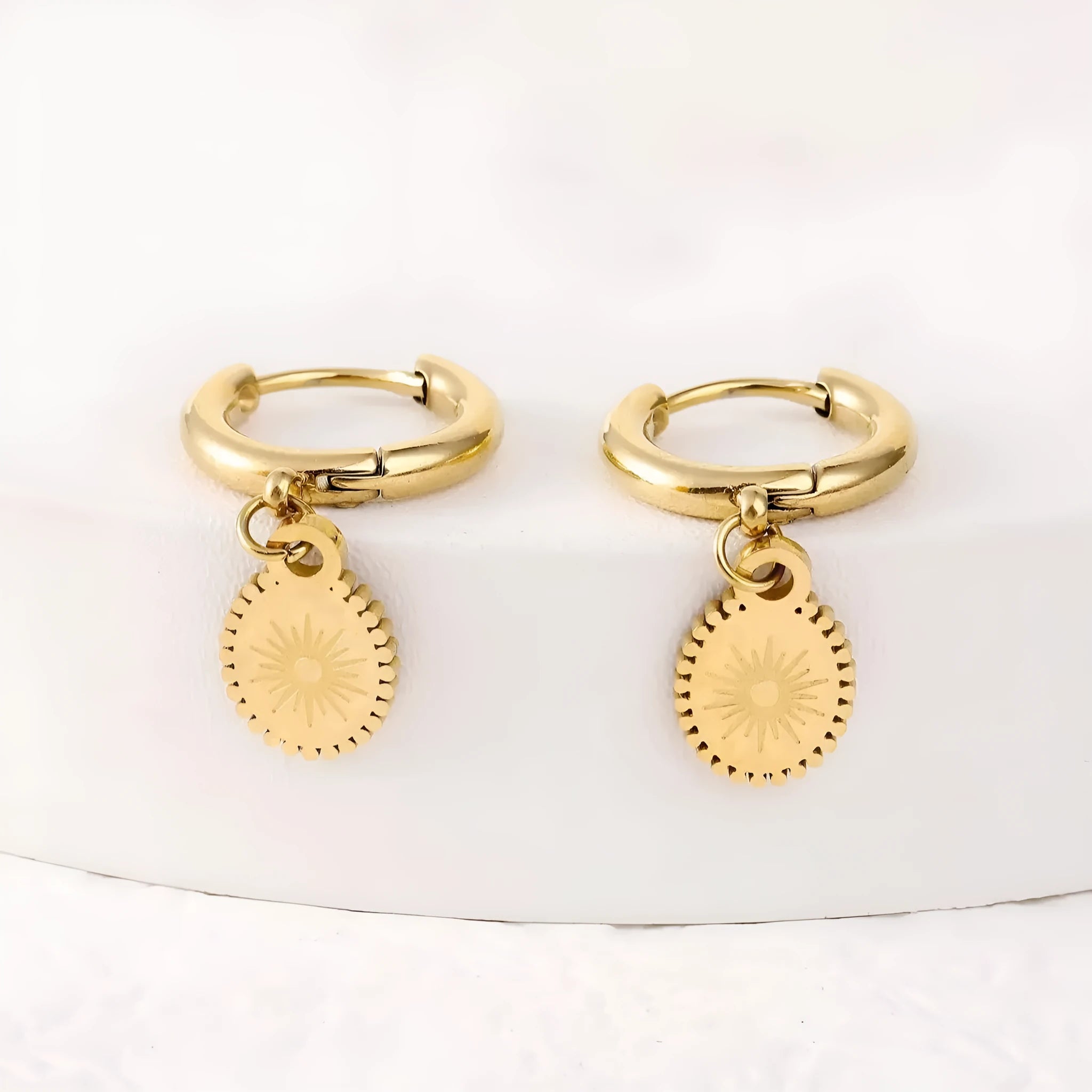 A pair of stainless steel ellipse-shaped stud earrings with butterfly clips on a white background.