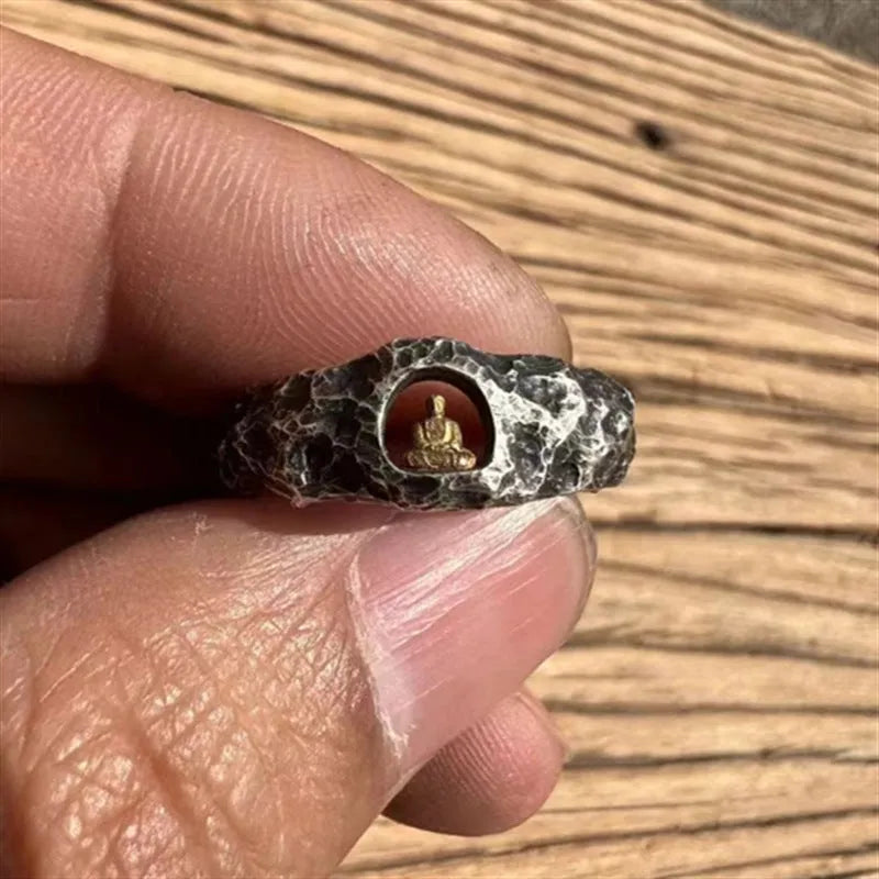 Close-up of a hand-forged copper Buddha ring with grotto design and rock texture on a size 8 finger.