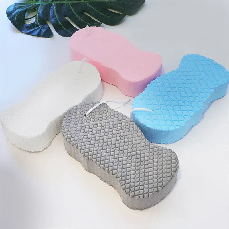 White 3D bath sponge with fish scale pattern for gentle body exfoliation in shower.