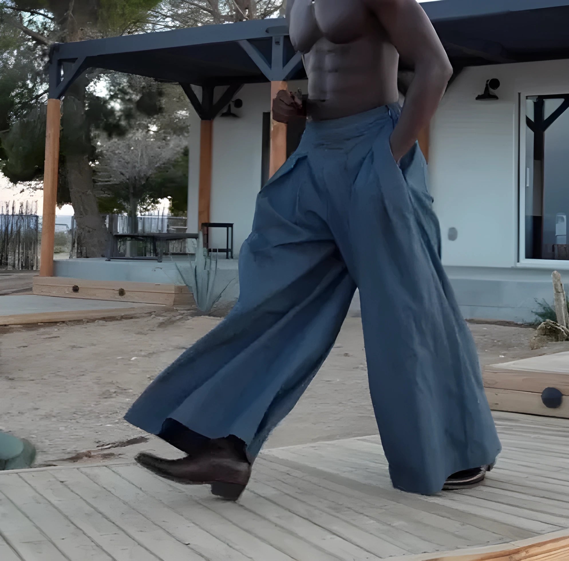Men's grey pleated wide-leg trousers with elasticated waistband laid flat