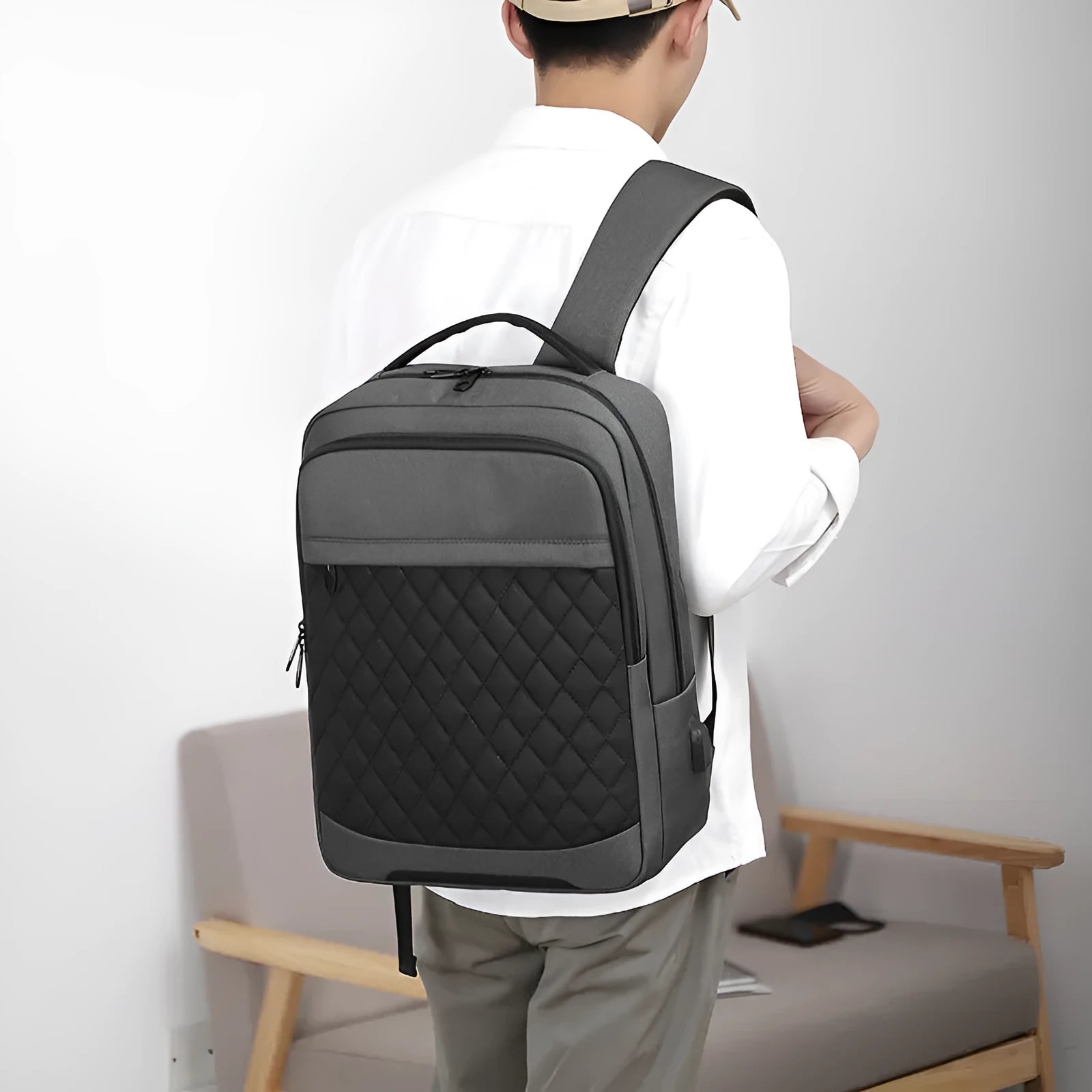 Men's solid colour Oxford cloth backpack with curved shoulder strap in black, blue, or grey.