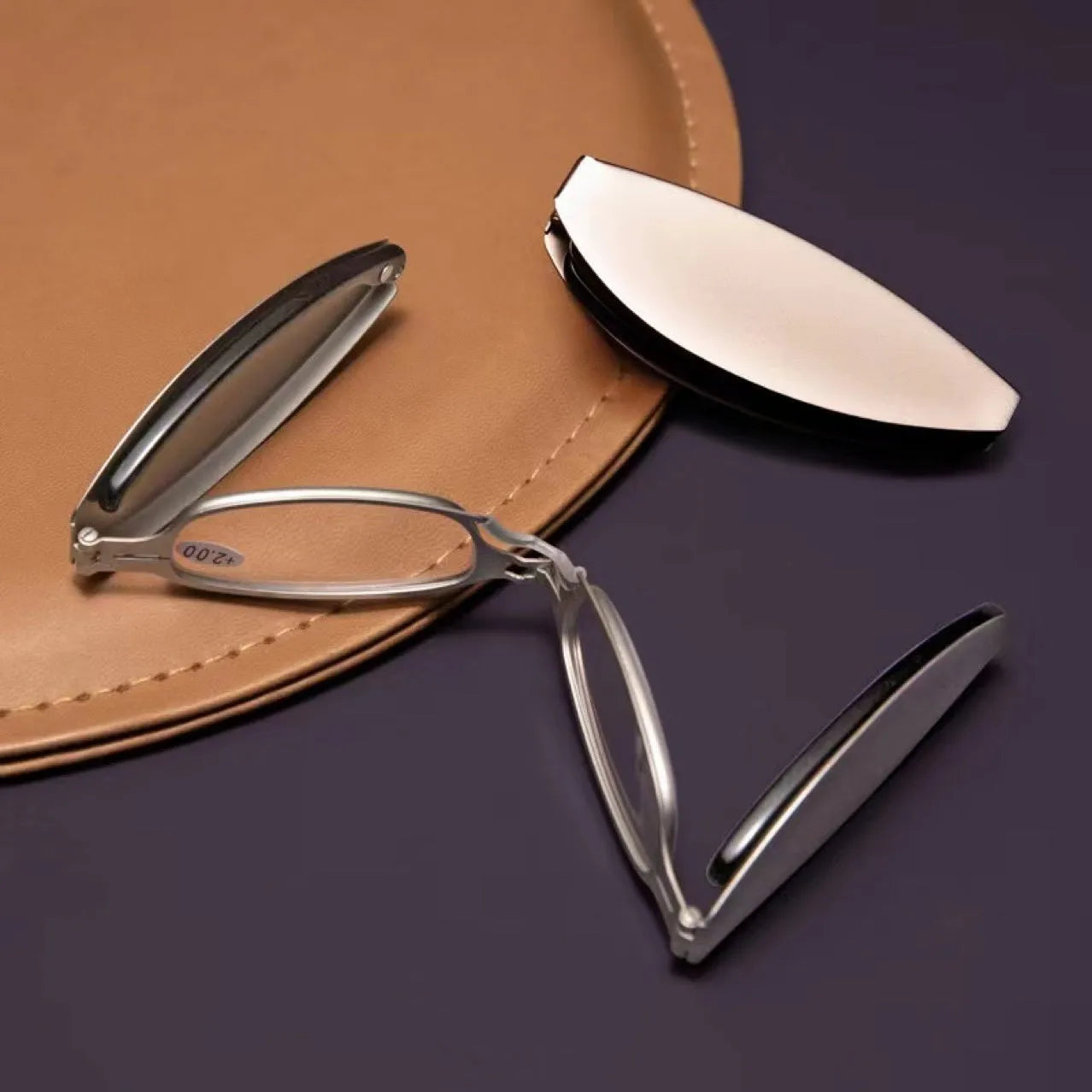 Black folding presbyopic glasses with metal frame and ring detailing shown open and folded