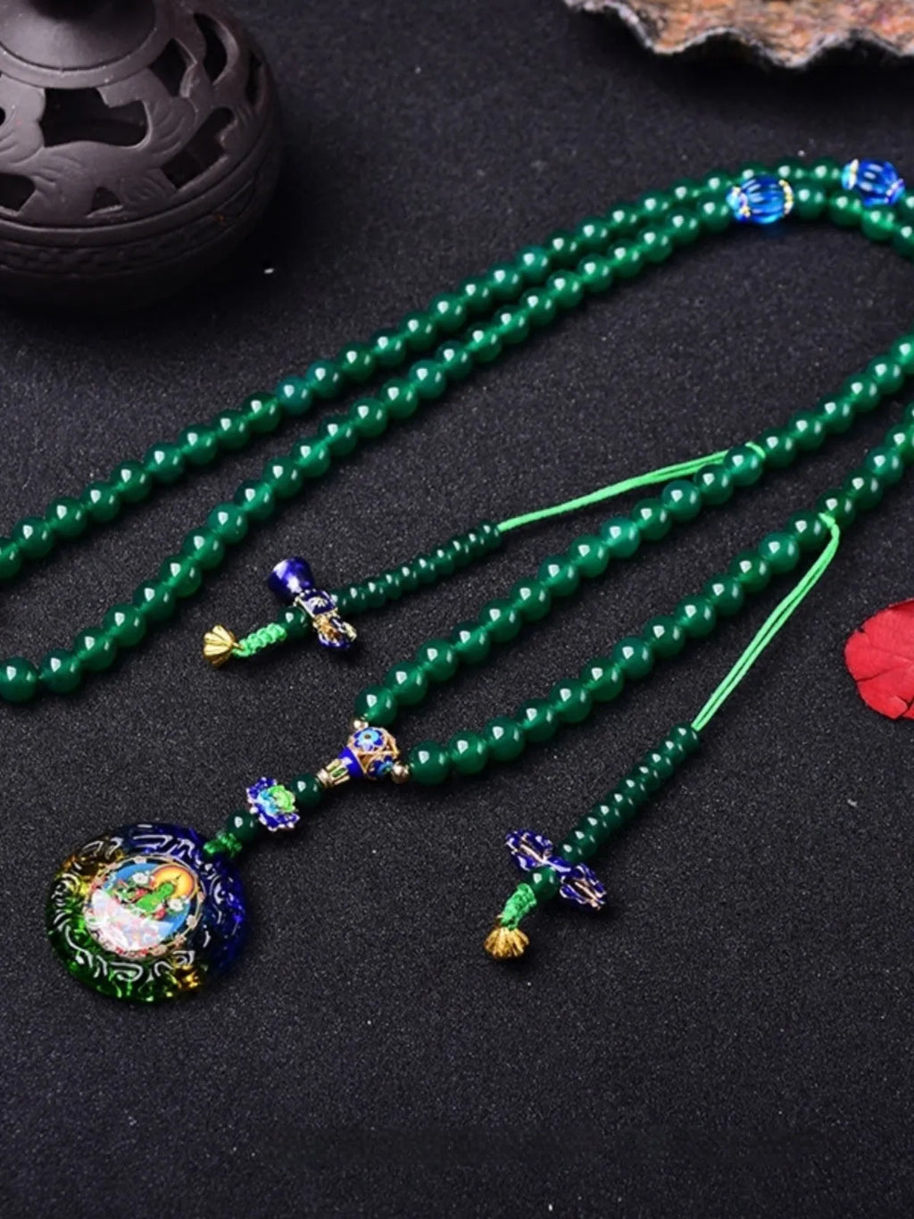 Handmade natural green agate 108 bead bracelet with thangka pendant on a wrist.