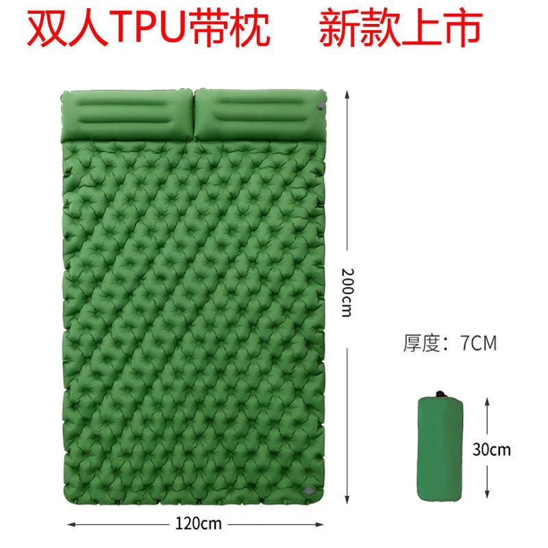 Double size inflated air mattress in army green colour with an attached pillow, on a grass surface.