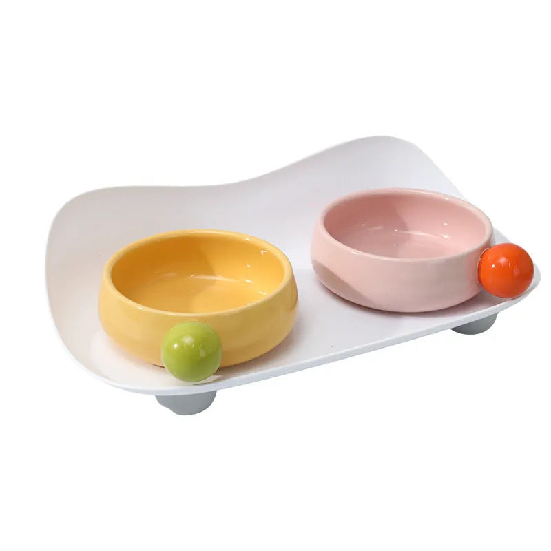 Raised ceramic pet feeding bowl set with two bowls in pink yellow colour on a non-slip base.