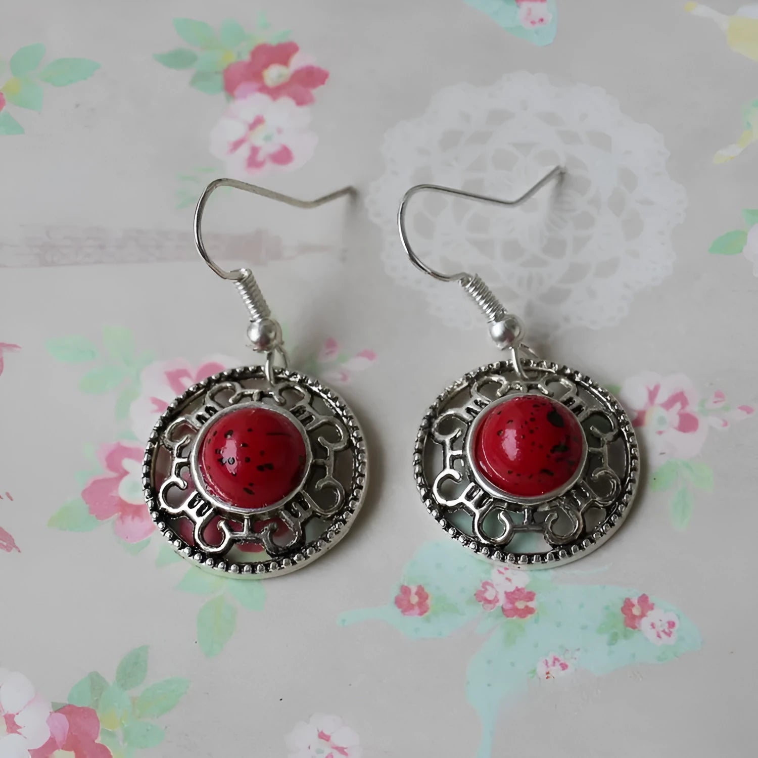 Handmade Miao silver retro earrings with turquoise flower disk and ethnic patterns in black.