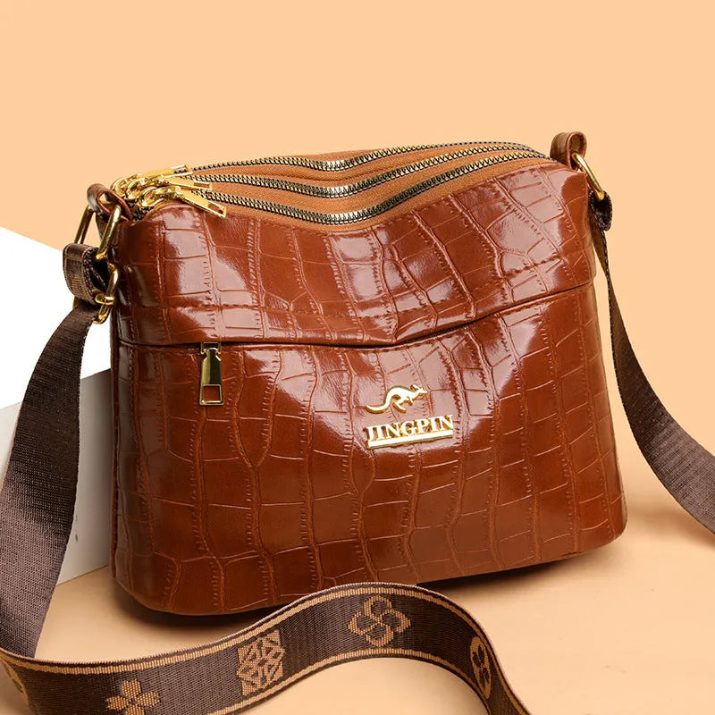 Brown cross body bag with multiple compartments and horizontal suitcase shape