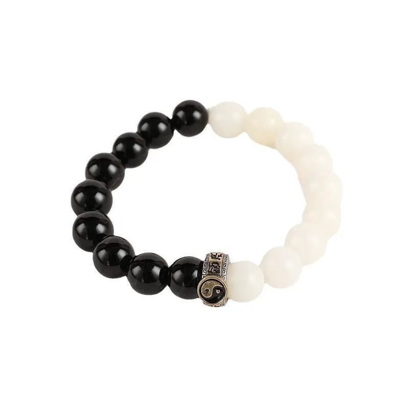 Black and white obsidian bracelet with Tai Chi symbol and mantra text on geometric beads.