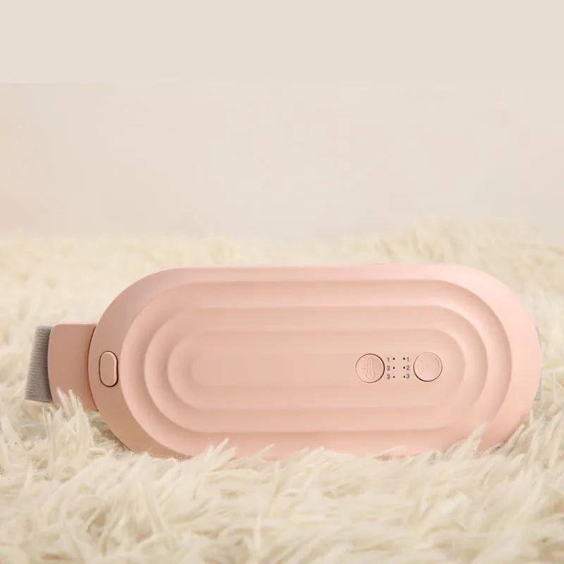 Pink and white menstrual heating belt with USB charger, controller, and long cable on a grey background.