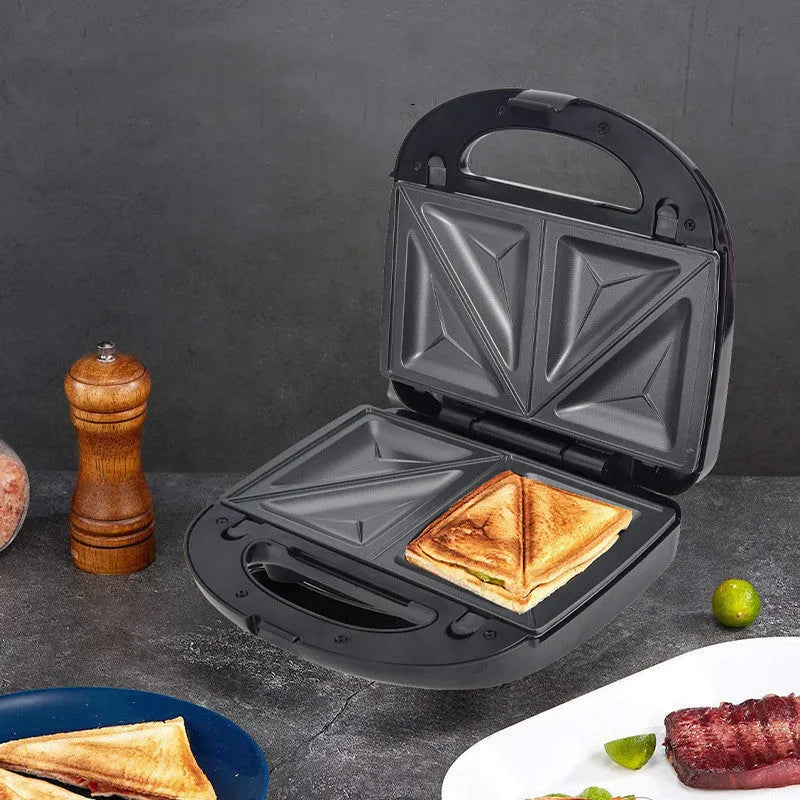 Black double-sided electric sandwich pan with brushed stainless steel lid and six removable non-stick plates.