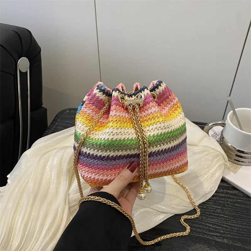Multicolor straw weave bucket bag with plaid pattern, chain strap, and diamond embellishments