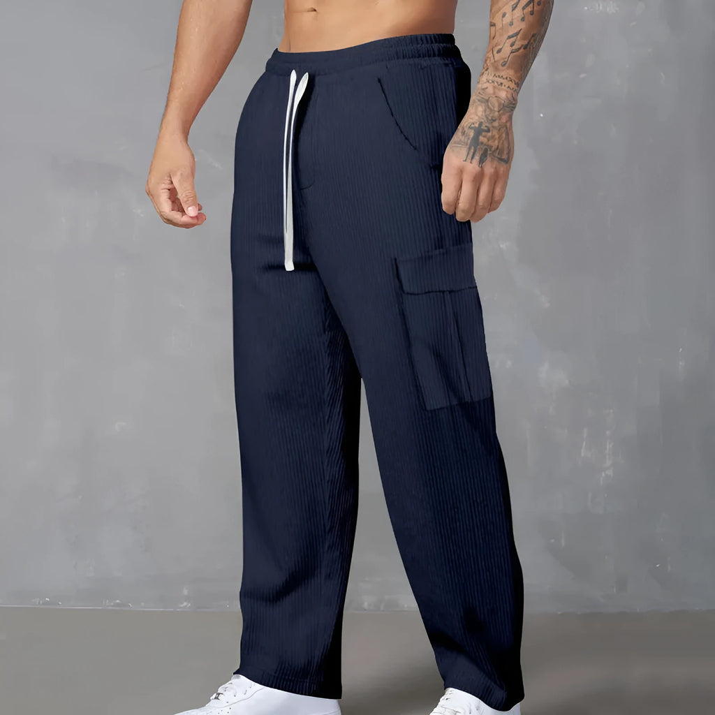 Men's navy blue corduroy cargo trousers with loose fit and straight legs on a hanger.