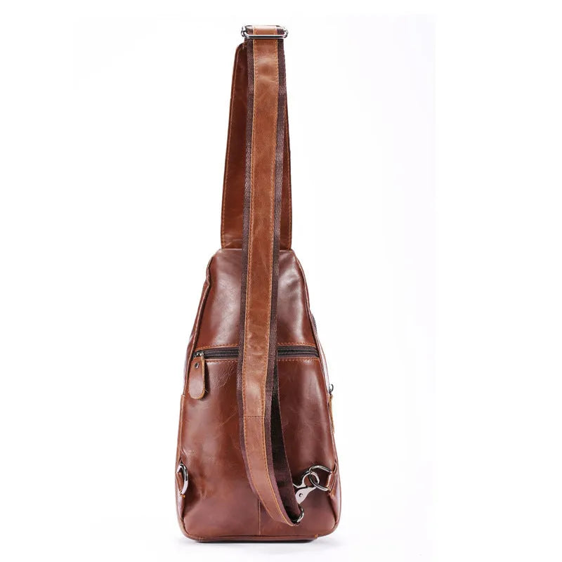 Men's brown cowhide leather crossbody bag with visible stitching and zip closure laid flat on a surface