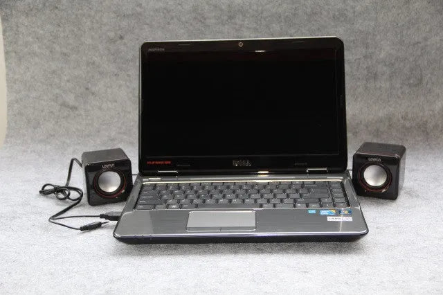 Black square USB-powered 2.0 desktop computer speaker on a desk.
