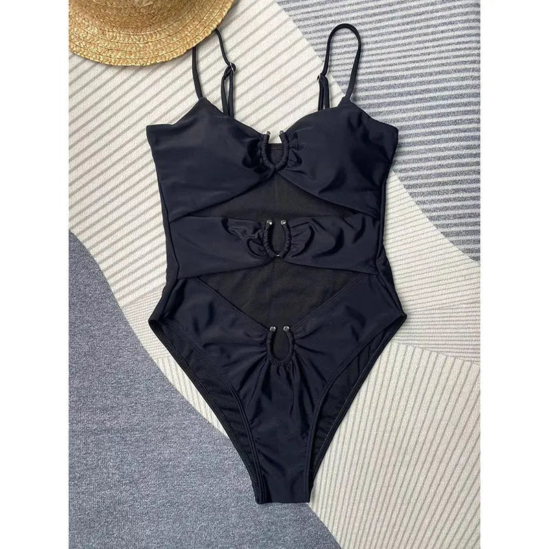 Black solid colour one-piece swimsuit for women on a mannequin, showing a tight fit.