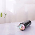 Black portable car humidifier with colourful lights on a car dashboard cup holder