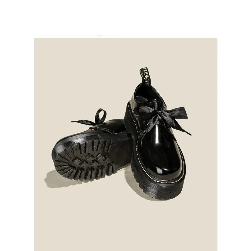 Black and white women's lace-up shoes with a thick sole, cross straps, and ribbon details.
