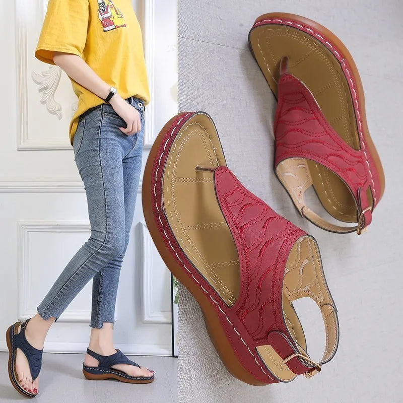 Women's red wedge heel sandals with an adjustable back strap buckle.