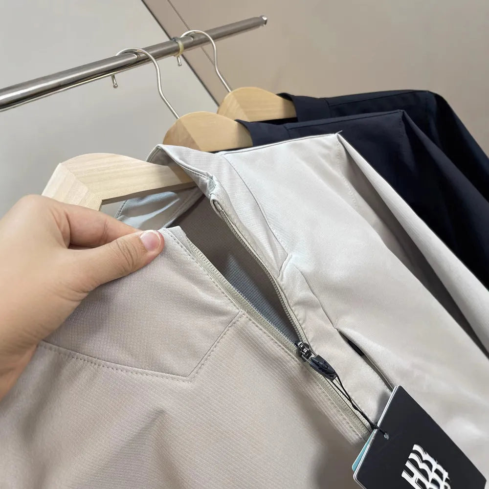 Men's beige stand collar casual sports jacket with long sleeves on a hanger.