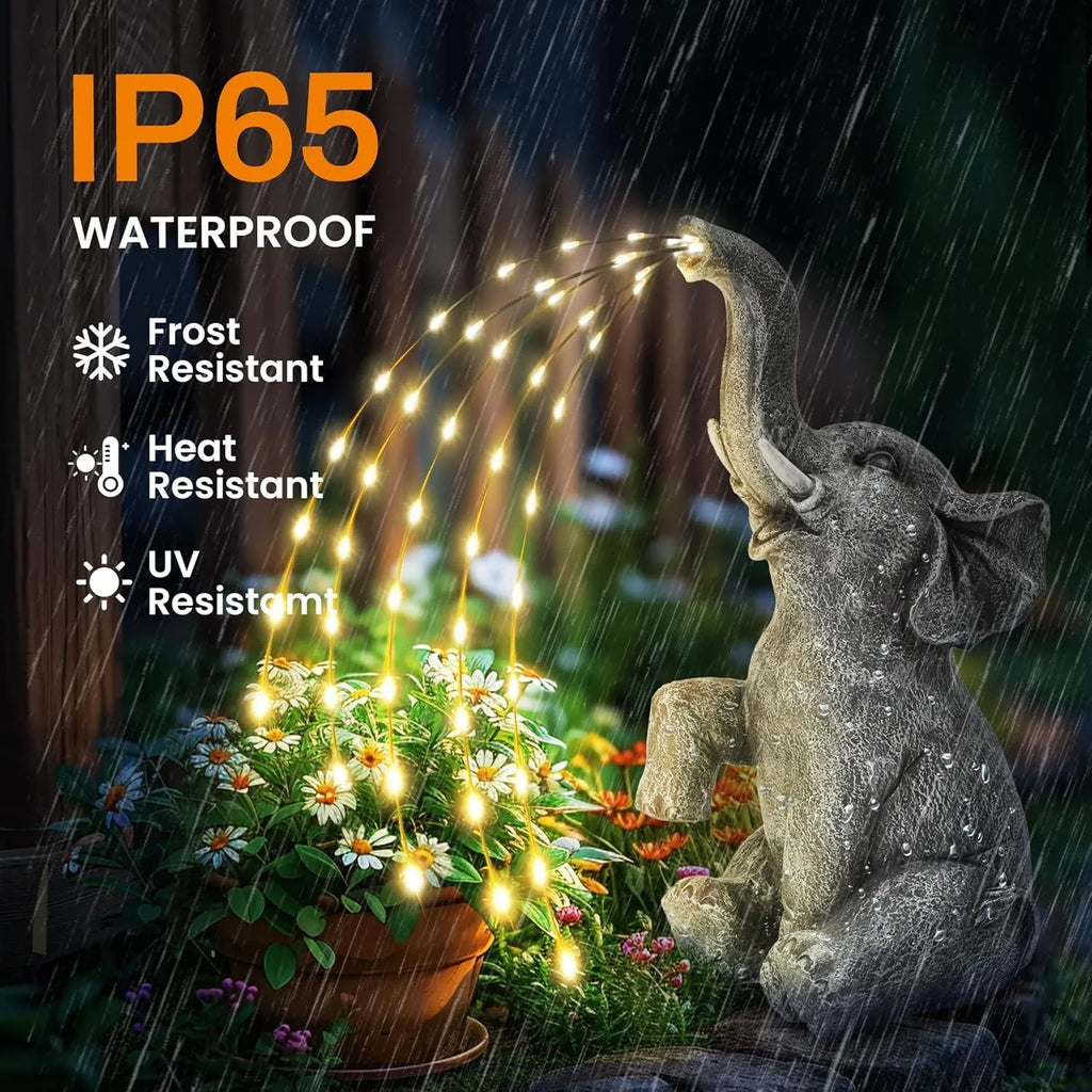 Resin elephant garden statue with built-in LED light strip on grass.
