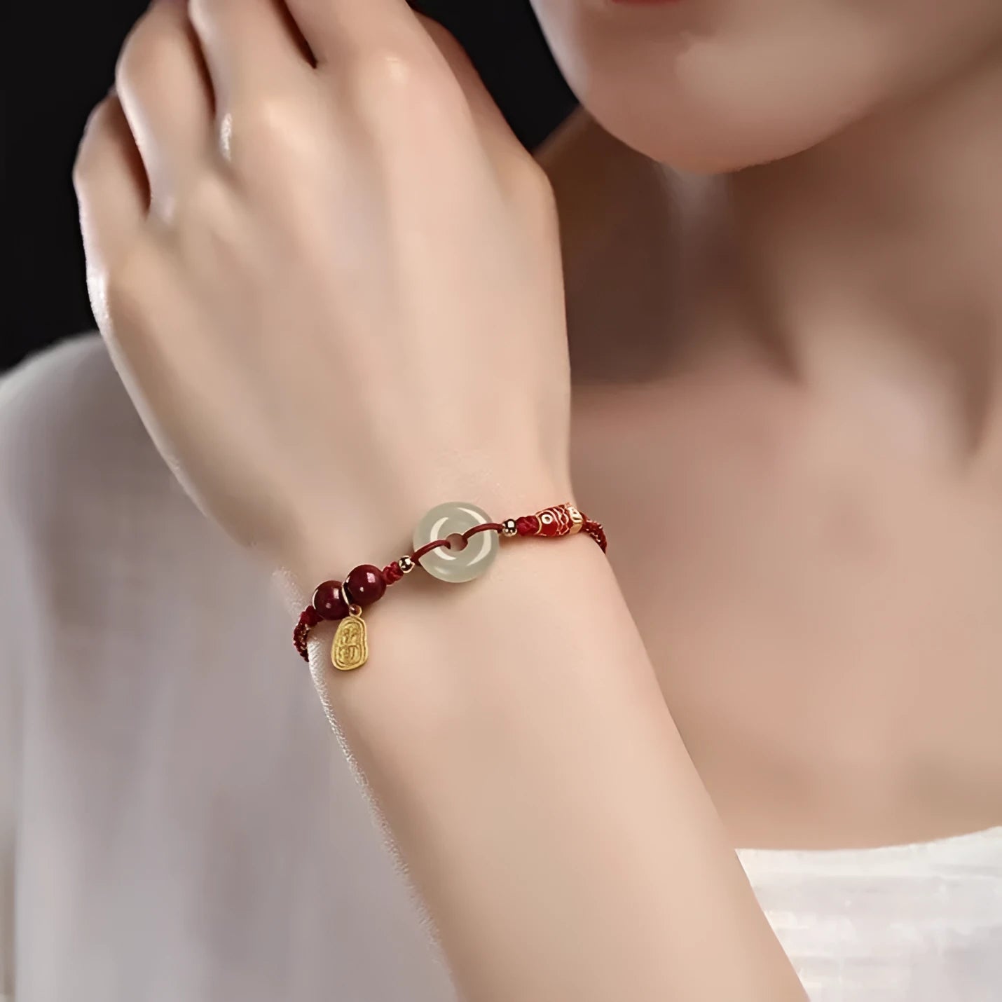Handmade bracelet with Hetian jade peace buckle charm on adjustable braided rope.