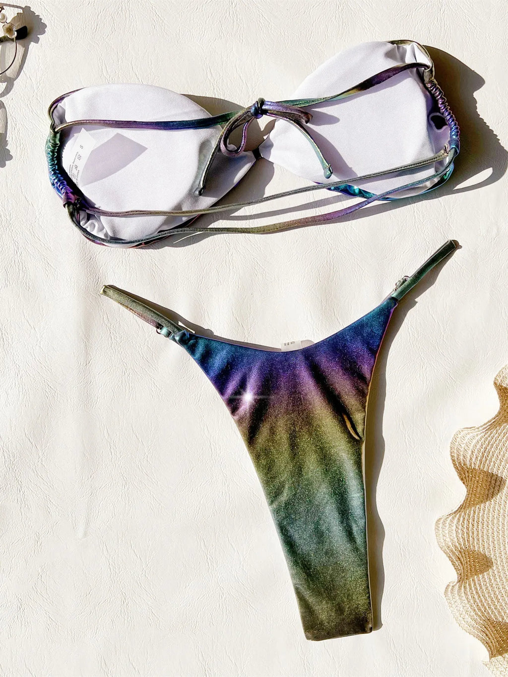 Women's gradient purple bikini swimsuit laid flat, showing top and bottom.