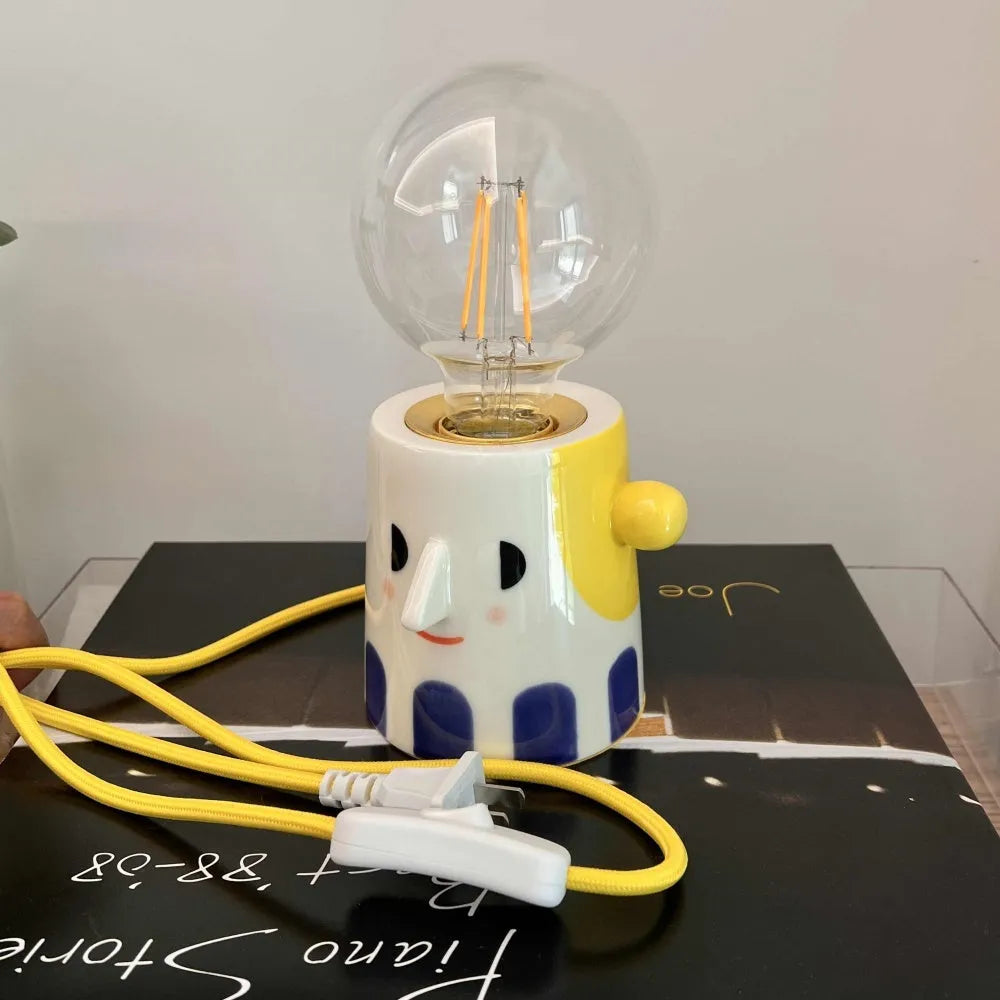 Handmade ceramic table lamp with a spherical white ball headlight shade on a solid base.