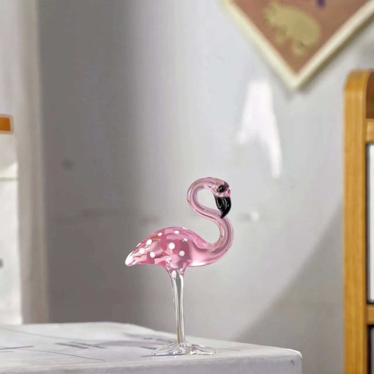 Pink crystal simulation flamingo decorative ornament on a table for home decor or gifting.
