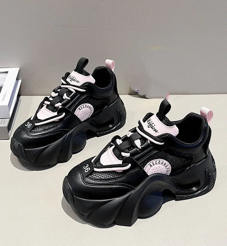 Women's pink sneakers with a thick sole, cross shoulder straps, and a mesh lining.