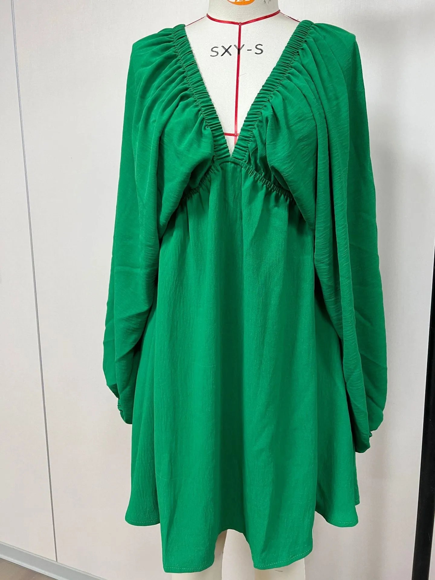 Women's apricot V-neck dress with puff sleeves and a flounced swing skirt, also available in green, black, and white.