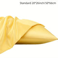 A pair of solid colour satin cloth pillowcases made from polyester plain weave fabric.