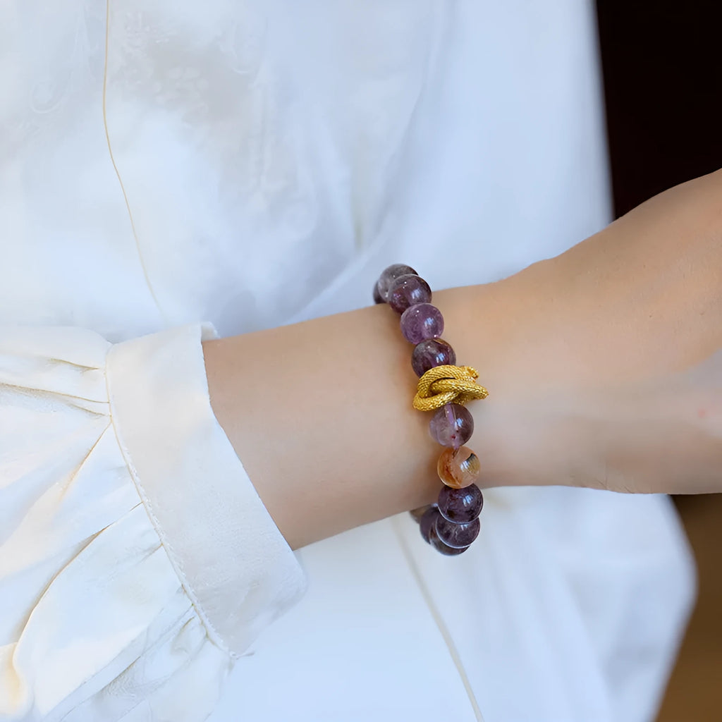 Purple cornucopia crystal bracelet with nine purple lucky charms on wrist