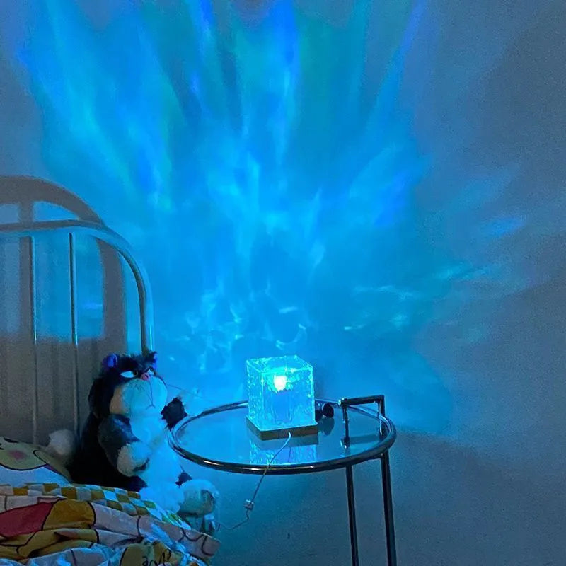 Rotating crystal table lamp projecting blue water ripple light pattern on wall