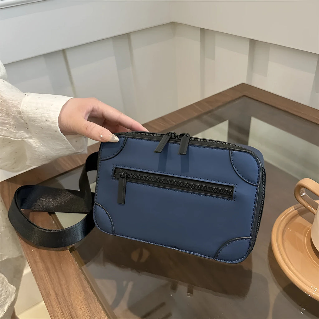 Small square women's crossbody bag in PU leather, shown in street-trend style with a single strap.