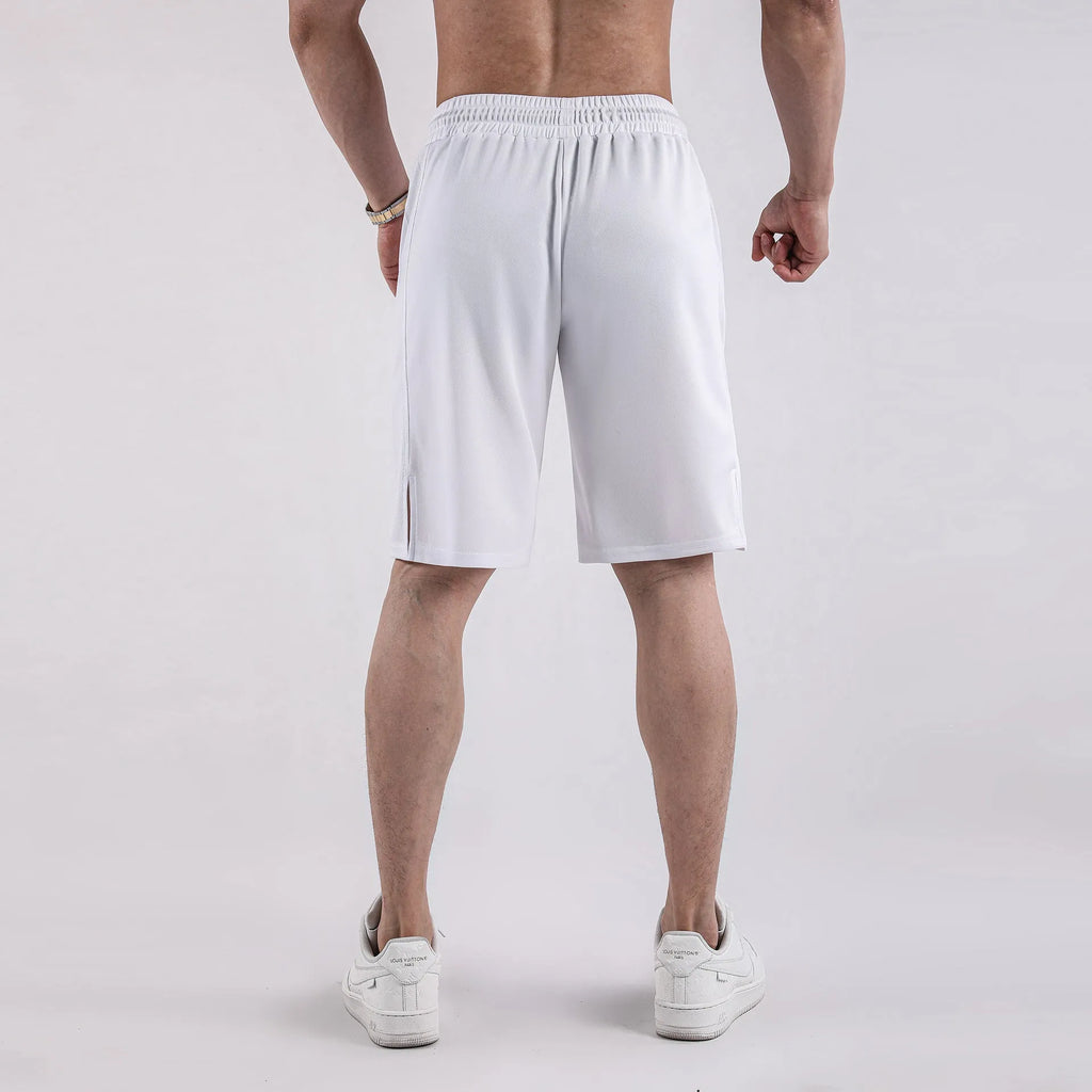 Man wearing black loose-fit mesh capri shorts with an elastic waist for sports.