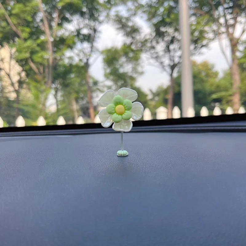 Small blue plastic swing decoration for a car dashboard, shown next to a coin for scale.