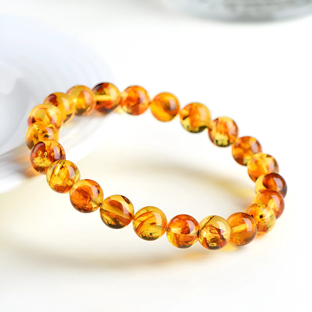 Natural yellow piebald amber bracelet with geometric beads on a wrist.